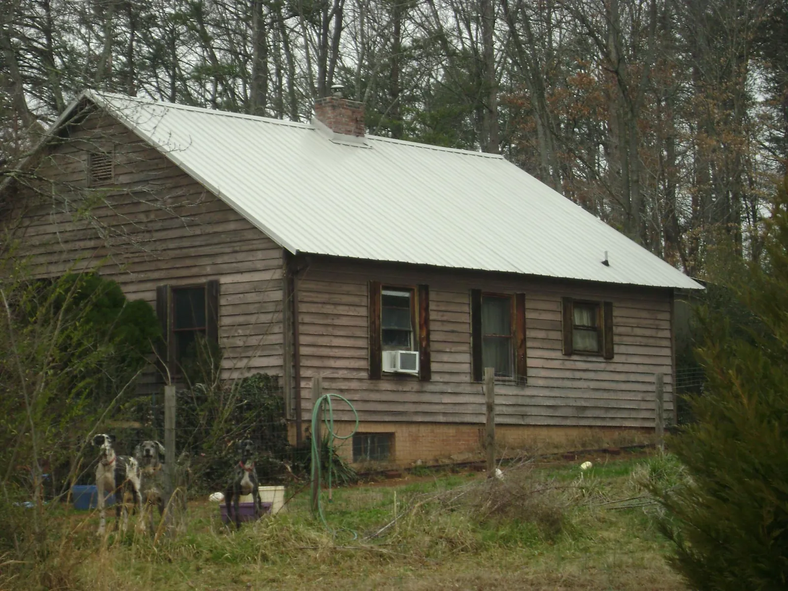 White metal roof on an old wood sided farmhouse, from a Metal Roof Installation job in Ames